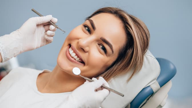 imagem procedimentos odontológicos odontologia clinica integrada, mulher sorrindo com médico com ferramentas analisando sua boca